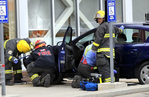 Winnipeg Fire Fighters care for a driver of a vehicle that struck the front window of the Shoppers Drug Mart on McPhillips Street at Leila Ave. Monday.  Wayne Glowacki / Winnipeg Free Press Nov. 4. 2013