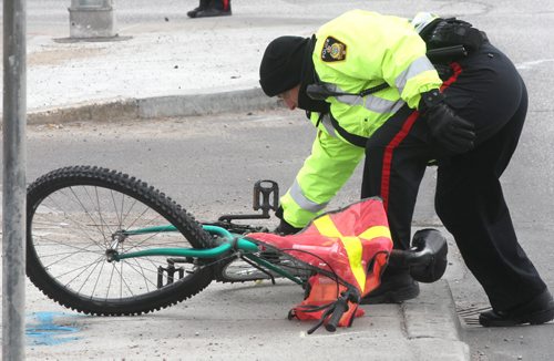Winnipeg Police Service members investigate car vs bike mva at Notre Dame Ave and Westin St near 11 am Monday- Witnesses say a man riding his bike was hit hard by a small white car travelling west bound on Notre Dame  Police have closed all traffic on westbound Notre Dame as they investigate crash-Breaking News- Nov 05, 2013   (JOE BRYKSA / WINNIPEG FREE PRESS)