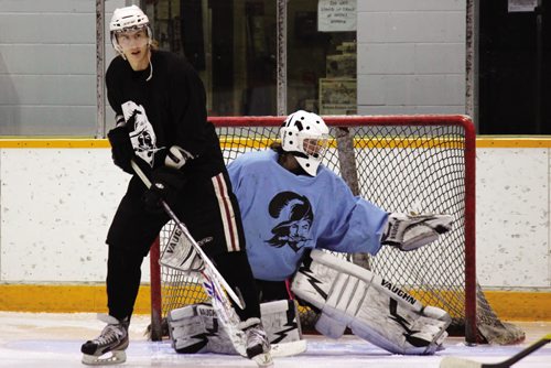 Canstar Community News Jordan Lisowick provides a screen in front of the net while Brenden Fiebelkorn makes a glove save during practice Wednesday evening. (JORDAN THOMPSON)