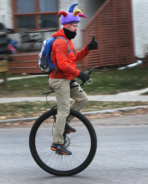 Keith Holm rides his 36 inch Nimbus unicycle down Wolseley Ave Wednesday morning Standup photo- Nov 06, 2013   (JOE BRYKSA / WINNIPEG FREE PRESS)