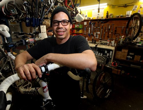 Adrian Alphonso poses at work as a bicycle technician Wednesday. He used the SEED program to learn how to save money and pay off his credit card. See Elizabeth Fraser story.  November 6, 2013 - (Phil Hossack / Winnipeg Free Press)