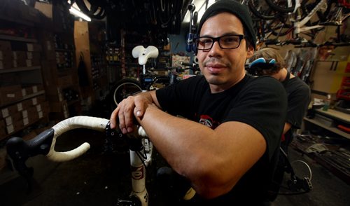 Adrian Alphonso poses at work as a bicycle technician Wednesday. He used the SEED program to learn how to save money and pay off his credit card. See Elizabeth Fraser story.  November 6, 2013 - (Phil Hossack / Winnipeg Free Press)