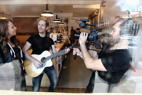 Chris Gaudry films singers Keith Macpherson and Renee Lamoureux in the Thom Bargen coffee shop on Sherbrook Avenue Thursday morning. Chris Gaudry is an independent videographer who shoots one-take videos of bands and artists in spots all over town - on the bus, in back alleys, etc. He then posts the videos on his YouTube channel - PocketGigs. 131108 - November 8, 2013 MIKE DEAL / WINNIPEG FREE PRESS