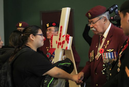 After placing her poppy on the cross Kaitlynn Kennedy shakes the hand  Joe Meconse, pres. Manitoba Chapter of the National Aboriginal Veterans Association of Canada  during  the Aboriginal Veterans Day ceremony. About 250 attended the ceremony at the Aboriginal Centre of Winnipeg Friday to acknowledge and honour the contributions Aboriginal Veterans have made to Canada and the world.      Wayne Glowacki / Winnipeg Free Press Nov. 8. 2013