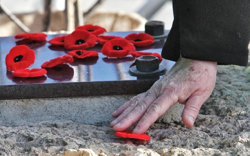 A poppy pin is placed on the Valour Road memorial during the Remembrance Day ceremonies.   131111 November 11, 2013 Mike Deal / Winnipeg Free Press