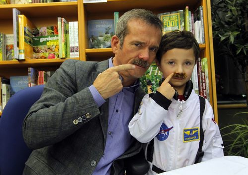 Chris Hadfield poses for a photo with 4 year old Kahy Thompson at Hadfields book signing (An Astronaut's Guide to Life on Earth) at McNally Robinson Booksellers. BORIS MINKEVICH / WINNIPEG FREE PRESS  November 13, 2013