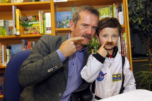 Chris Hadfield poses for a photo with 4 year old Kahy Thompson at Hadfields book signing (An Astronaut's Guide to Life on Earth) at McNally Robinson Booksellers.  BORIS MINKEVICH / WINNIPEG FREE PRESS  November 13, 2013