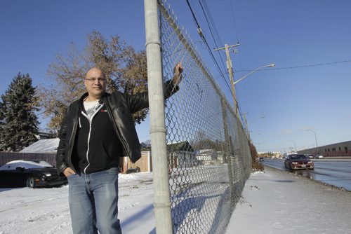 Alan Castell by the fence behind his home on Queen Street that runs along Century St. The Winnipeg  Chamber of Commerce wants to erect a wall along his back lane, part of a $7 million initiative to beautify the airport-to-downtown traffic route. Aldo Santin story   Wayne Glowacki / Winnipeg Free Press Nov. 18. 2013