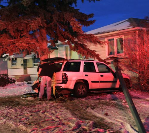 "Be careful, it's very icy out there" is the message this SUV driver has for other motorists as he unloads his vehicle on the front yard of a home at 1075 Nairn Ave. Wednesday morning. He was travelling west bound on Nairn Ave., lost control on the ice and hit a light standard that fell on the home. No one was injured.   Wayne Glowacki / Winnipeg Free Press Nov. 20. 2013