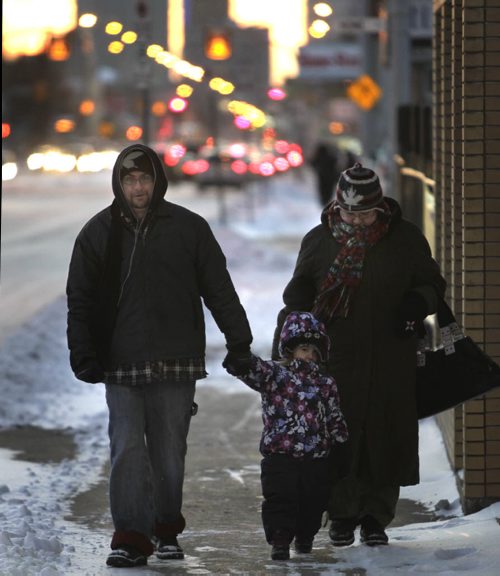 Eric Lafontaine and Tanya Smith with their daughter Nelligan walk down Notre Dame Ave. on a cold -15C Thursday morning.  With  weather story.   Wayne Glowacki / Winnipeg Free Press Nov. 21. 2013