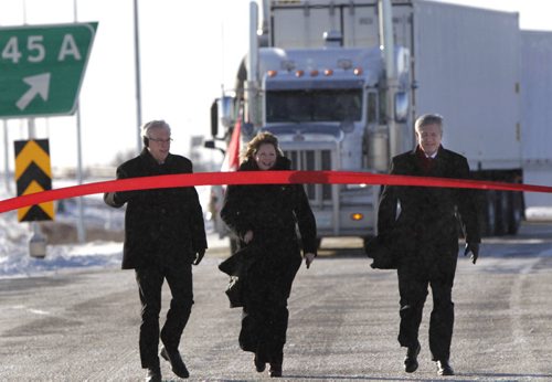 From right, Prime Minister Stephen Harper,Diane Gray, CentrePort's president and CEO and Premier Greg Selinger walk up to their ribbon cutting task to officially open the first section of the new CentrePort Canada Expressway in Winnipeg Friday. CentrePort is the 8,093-hectare inland port and transportation hub being developed northwest of the airport. Wayne Glowacki / Winnipeg Free Press Nov. 22. 2013