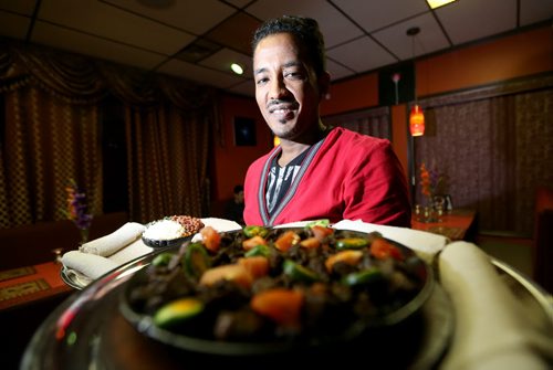 Girma Tessema, owner of Blue Nile Restaurant, holding the Kitfo Special and Chacha Beef at Blue Nile, Saturday, November 23, 2013. (TREVOR HAGAN/WINNIPEG FREE PRESS) - restaurant review.