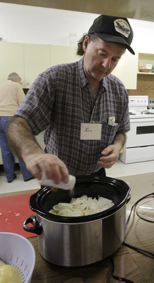 Faith Page.. In the  basement of the Lutheran Church of the Cross, Ron Redding who is learning crockpot cooking adds salt to his Pork and Apple Casserole.    Brenda Suderman story.  Wayne Glowacki / Winnipeg Free Press Nov. 25. 2013