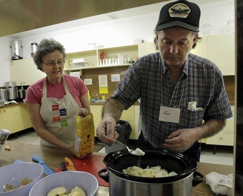 Faith Page.. In the  basement of the Lutheran Church of the Cross, Ron Redding who is learning crockpot cooking adds flour to his Pork and Apple Casserole beside volunteer instructor Judy Dikkema.     Brenda Suderman story.  Wayne Glowacki / Winnipeg Free Press Nov. 25. 2013
