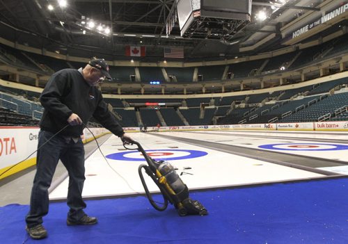 Eric Monford vacuums the carpet by the curling ice at the MTS Centre in Winnipeg Monday night in preparation for the Tim Hortons Roar of the Rings curling competition which will run December 1-8, 2013- The winner from mens and ladies rinks will represent Canada at the Sochi 2014 Winter Olympic Games Standup photo- Nov 25, 2013   (JOE BRYKSA / WINNIPEG FREE PRESS)