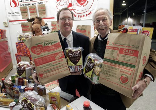 At left, John Graham, with Canada Safeway and Kai Madsen, Executive Director with the Christmas Cheer Board at the launch of the annual Safeway/Christmas Cheer Board grocery bag to collect food for hampers.The bags are distributed by the Winnipeg Free Press and can be filled and dropped off at any Safeway location. Five and ten dollar care packages for hampers can also be purchased at Safeway stores with shoppers collecting a bonus 5 or 10 air miles till Dec.12.    Alex Paul story  Wayne Glowacki / Winnipeg Free Press Nov. 26. 2013