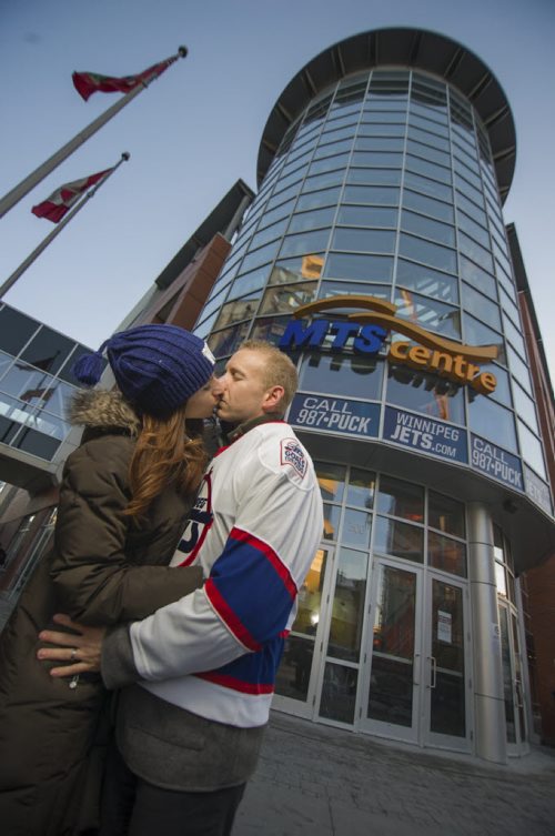 131126 Winnipeg - DAVID LIPNOWSKI / WINNIPEG FREE PRESS (November 26, 2013)  Kim Babij-Gesell and husband Taren Gesell kiss outside of the MTS Centre on Tuesday. For a story on the KISS CAM at  Winnipeg Jets games and people's experiences getting caught on them. Kim and Taren are in the story as one of those couples.    [David Sanderson story for 49.8 - INTERSECTION SECTION]