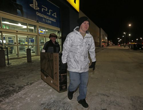 dozens of cars  were outside the Best Buy after 6am- Black Friday starts in WPG Äì Tobin Douglas  (front) gets help frm his dad Peter Kidd  after a 6am  opening  he bought a 50 in TV purchase at Best Buy on St  James St  / Nov. 29 2013 / KEN GIGLIOTTI / WINNIPEG FREE PRESS