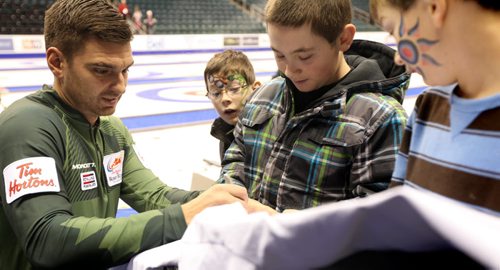 Matt Woznial signs his autographs for young curling fans before going onto the ice for a practice round  at MTS Centre Saturday during TIm Hortons Roar of the Rings Canadian Curling Trials which starts Sunday at MTS Centre.   Nov 30, 2013 Ruth Bonneville / Winnipeg Free Press