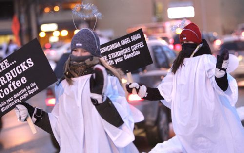 At left, Reid Wrublowsky and her sister Megan were among the dozens of Angel Squad  volunteers on the Maryland Bridge Tuesday morning helping raise money for  Misericordia Health Centre Foundation.  Drivers who donate were treated to coffee, a pastry and a copy of the Winnipeg Free Press. Wayne Glowacki / Winnipeg Free Press Dec.3 2013