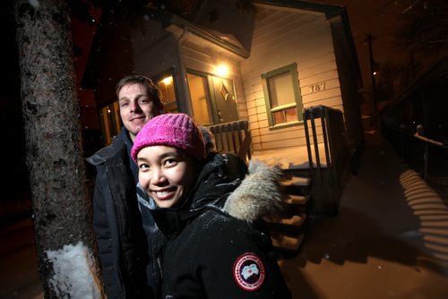 Chris Davidson and Shuhsien Zhu pose in front of their Crescentwood home.  This weekend's Money Matters is about the challenges of being a first-time home buyer in a booming real estate market. The hottest segment in the city is the $200,000 to $250,000 range, the price point for many newbies to the home buying game. Not only is  it highly competitive, but changes to lending rules over the last few years have made it increasingly difficult for first-time to qualify for the right mortgage with an affordable monthly payment. Contact for the story is Shuhsien Zhu, who along with her husband  recently bought a home in Crescentwood for around $200,000. They didn't have too much trouble finding their small fixer-upper, but they could have spent much more as their bank had approved them for a whopping $600,000 mortgage. December 4, 2013 - (Phil Hossack / Winnipeg Free Press)
