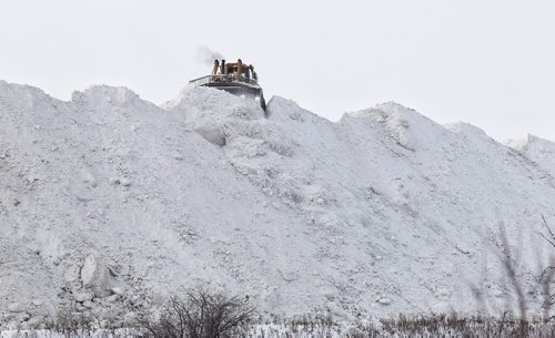 The snow mountain at the Snow Disposal Site on Kenaston Blvd. is growing quickly as almost a constant stream of trucks arrive to deliver loads of snow from city streets and parking lots. 131205 - December 5, 2013 MIKE DEAL / WINNIPEG FREE PRESS