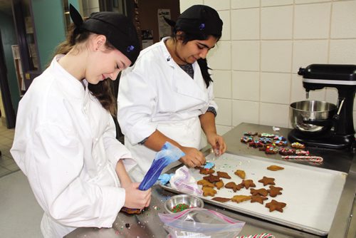 Canstar Community News Shantel Laycock (left) and Sakshi Saul, Grade 8 students at General Byng School, put the finishing touches on some cookies in Winnipeg Technical College's culinary arts classroom during a day of hands-on experience for students in the Pembina Trails school division. (JORDAN THOMPSON)