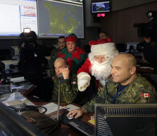 Santa and one of his elves made their annual visit to get his pre-flight operational briefing by members including Warrant Officers at right Pascal Germain and Perry Stadler of the Canadian NORAD Region inside the Combined Aerospace Operations Center at the 1 Canadian Air Division/CANR Headquarters Friday morning.   During the 2013 NORAD Tracks Santa Operation personnel will be ensuring Santa a safe passage through Canadian airspace on Christmas.see release. Wayne Glowacki / Winnipeg Free Press Dec.6 2013