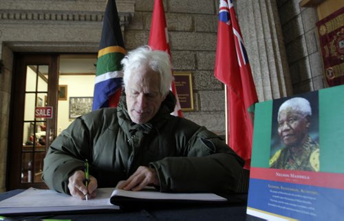 Terry Fohster signs the book of condolences for the late Nelson Mandela in the foyer of the Manitoba Legislative building Friday.. Larry Kusch story  Wayne Glowacki / Winnipeg Free Press Dec.6 2013