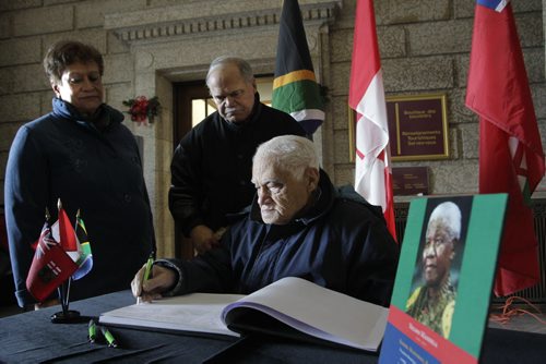 Bill Rhoda (seated) along with his son Stan Rhoda and daughter-in-law Helen Rhoda signed the book of condolences for the late Nelson Mandela in the foyer of the Manitoba Legislative building Friday. Bill Rhoda attended the University of Fort Hare at the same time as  Nelson Mandela.  Larry Kusch story  Wayne Glowacki / Winnipeg Free Press Dec.6 2013