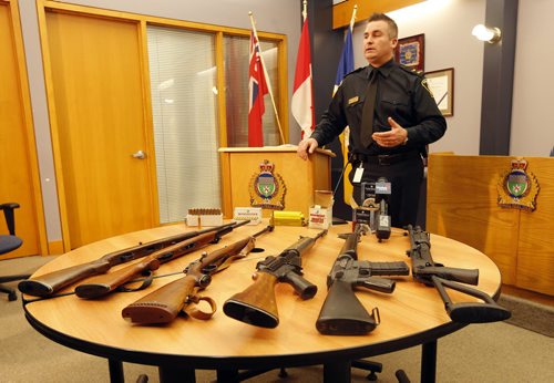 Constable Jason Michalyshen  in pic with guns at  Wpg Police Service Newser , WPS seized drugs and guns from two residences in the 500 block of Chalmers Ave and 3 occupants arrested  and  were taken into custody , a quantity of Meth , Marijuana  hunting and assault weapons were seized in the raid . ** weapons on display were not seized from this arrest , those are still being processed , these represent the kinds of guns found  Dec. 9 2013 / KEN GIGLIOTTI / WINNIPEG FREE PRESS