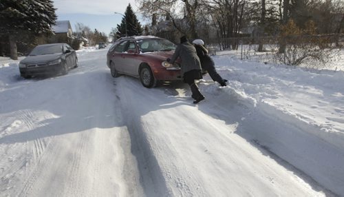 Julie Brown near her home on Chalmers Ave. gets help from fellow motorists to free her car that slipped out of the icy ruts and was temporarily stuck.  story  Wayne Glowacki / Winnipeg Free Press Dec.9 2013