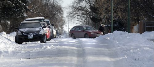 Julie Brown near her home on Chalmers Ave. tries to free her car after it slipped out of the icy ruts and was temporarily stuck. With story  Wayne Glowacki / Winnipeg Free Press Dec.9 2013