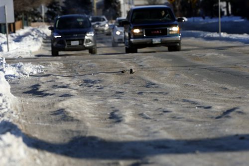 ruts  on ness Ave at Sturgeon Rd , Last weeks snow fall  has  left pack snow and ice  rut hazards to traffic. The city has chosen not to scrape the streets to the pavement .  Dec. 9 2013 / KEN GIGLIOTTI / WINNIPEG FREE PRESS