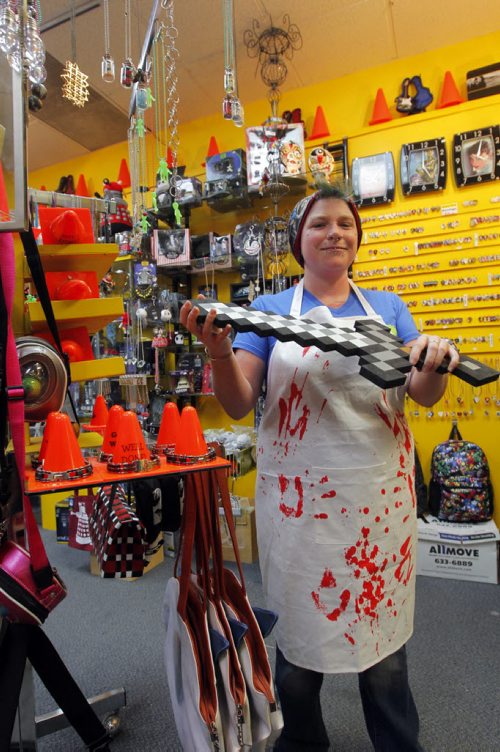 49.8 - INTERSECTION - Christmas Gift Guide Gifts. Pylon sells a butcher's apron that looks like chef is covered in blood. Employee Sandra Sturrock poses for a photo. BORIS MINKEVICH / WINNIPEG FREE PRESS  December 9, 2013