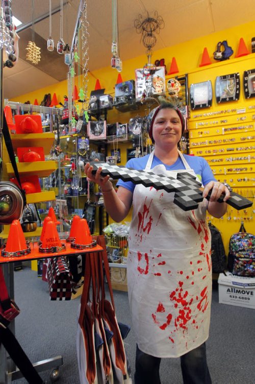 49.8 - INTERSECTION - Christmas Gift Guide Gifts. Pylon sells a butcher's apron that looks like chef is covered in blood. Employee Sandra Sturrock poses for a photo. BORIS MINKEVICH / WINNIPEG FREE PRESS  December 9, 2013