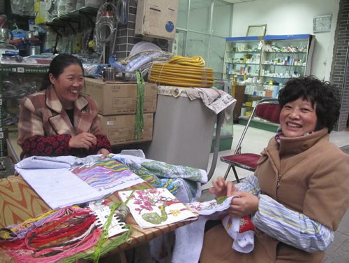 Gerald Flood / Winnipeg Free Press Women do needle work while waiting for customers at a plumbing supply store in Chengdu. November 2013