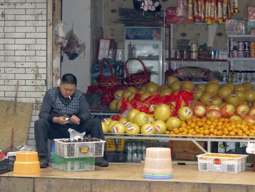 Shop keeper prepares fruits for sale in store in Chengdu. Gerald Flood / Winnipeg Free Press November 2013