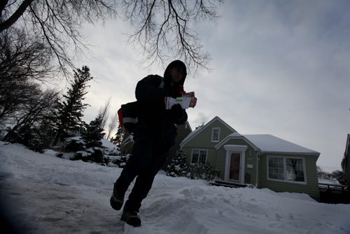 A letter carrier with Canada Post makes his way toward Grosvenor Ave. in River Heights later afternoon on Wednesday on the day the Canada Post announced the end of the era for home delivery mail service  See Storyl Dec 11, 2013 Ruth Bonneville / Winnipeg Free Press