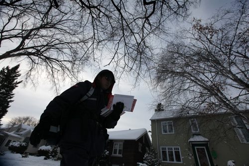 A letter carrier with Canada Post makes his way toward Grosvenor Ave. in River Heights later afternoon on Wednesday on the day the Canada Post announced the end of the era for home delivery mail service  See Storyl Dec 11, 2013 Ruth Bonneville / Winnipeg Free Press