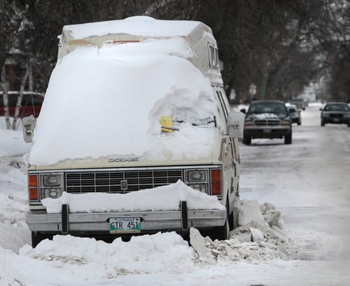 Residential Parking Ban. A vehicle on Amherst St. in St. James is ticketed as snow cleaning carried on around it.   Wayne Glowacki / Winnipeg Free Press Dec.12. 2013