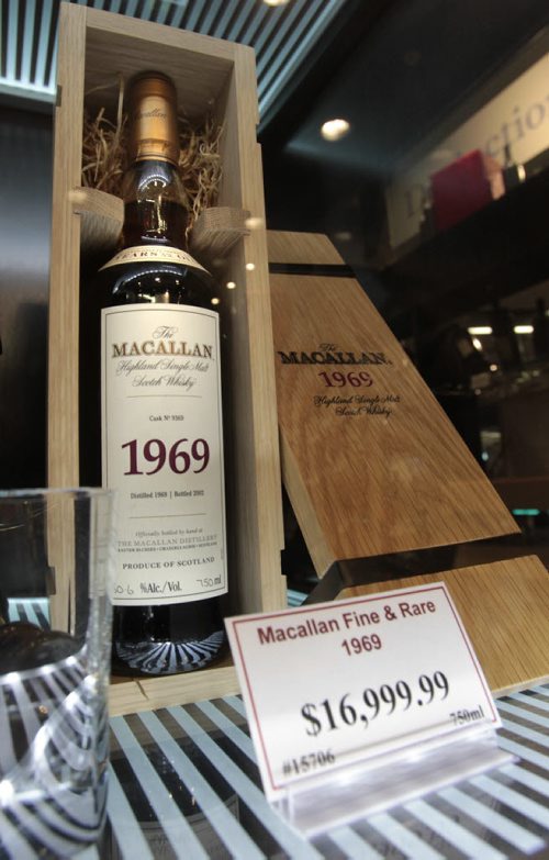 Rare and unique bottles in the glass room called  Distinctions in the Grant Park Liquor Mart Friday. This is a bottle of Macallan  1969 Scotch.  With Veronika Gorlova  story Wayne Glowacki / Winnipeg Free Press Dec.13. 2013