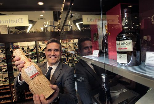 Ben Rusch, Manager of Product Education with Manitoba Liquor & Lotteries holds a bottle of Shackleton- The Journey Scotch Whisky by a bottle of The Last Drop cognac in a display cabinet in the glass room called  Distinctions in the Grant Park Liquor Mart Friday. With Veronika Gorlova  story Wayne Glowacki / Winnipeg Free Press Dec.13. 2013