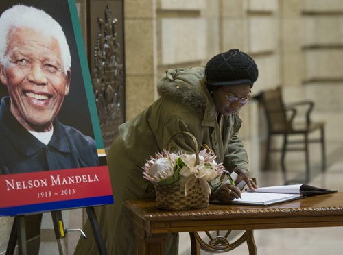 131214 Winipeg - DAVID LIPNOWSKI / WINNIPEG FREE PRESS (December 14, 2013)  Titi Tijani signs a memorial book for Nelson Mandela during a tribute to the former South African president Saturday afternoon at the Grand Staircase of the Legislative Building. Tijani who moved to Canada from Nigeria 27 years ago, is the Vice President of the African Communities of Manitoba Inc, and spoke at the tribute.