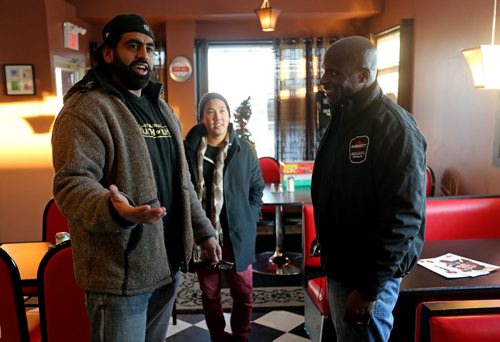Obby Khan, former Winnineg Blue Bomber and owner of Shawarma Khan, and Johnny Kien, owner of Saigon Jon's, arrive to support Milt Stegall inside Thea's Diner in Morris, Manitoba. Stegall flew up from Atlanta to show support for Thea Morris in the small community, Saturday, December 14, 2013. (TREVOR HAGAN/WINNIPEG FREE PRESS)