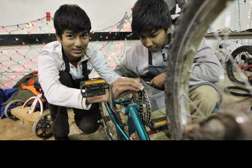 Brothers Jack Nai (left), 15, and John, 13, work on a bike together. Volunteers get together at the Orioles Communtiy Centre for a 24-hour bike repair marathon. Over 250 bicycles were repaired for children whose families can't afford to buy one for Christmas. 131215 - December 15, 2013 MIKE DEAL / WINNIPEG FREE PRESS