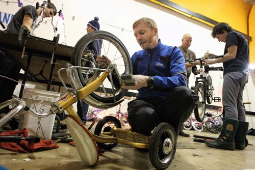 Jayson Gillespie the Manitoba Provincial Cycling Team Coach works on a tricycle during the marathon. Volunteers get together at the Orioles Communtiy Centre for a 24-hour bike repair marathon. Over 250 bicycles were repaired for children whose families can't afford to buy one for Christmas. 131215 - December 15, 2013 MIKE DEAL / WINNIPEG FREE PRESS