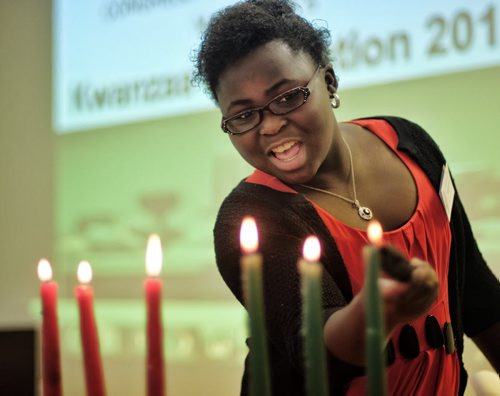 Tolu Oladele lights the last candle during a Kwanzaa celebration hosted by the Congress of Black Women of Manitoba at the Caribbean Community Cultural Centre on Fife Avenue Sunday afternoon. 131215 - December 15, 2013 MIKE DEAL / WINNIPEG FREE PRESS