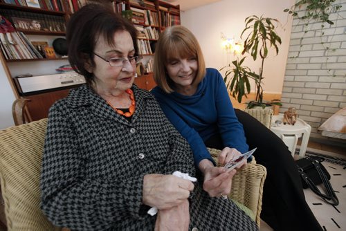 December 15, 2013 - 131215  -  Marnie Barker (R) and  Debby Lexier look at old photos in Lexier's home Sunday, December 15, 2013. Barker and Lexier first met in 1967 when Lexier came across Barker and her friend unknowingly drawing swastikas in the snow. John Woods / Winnipeg Free Press