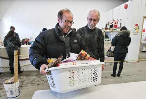 Winnipeg Mayor Sam Katz is greeted by Kai Madsen at the Winnipeg Cheer Board as he delivers boxes of supplies while on a tour of four non-profits today (Cheer Board, Harvest, Agape Table, United Way). Manitobans remain the most generous of all Canadian citizens for the 15th consecutive year (giving largest % of income to charity and claiming most tax receipts). 131216 December 16, 2013 Mike Deal / Winnipeg Free Press